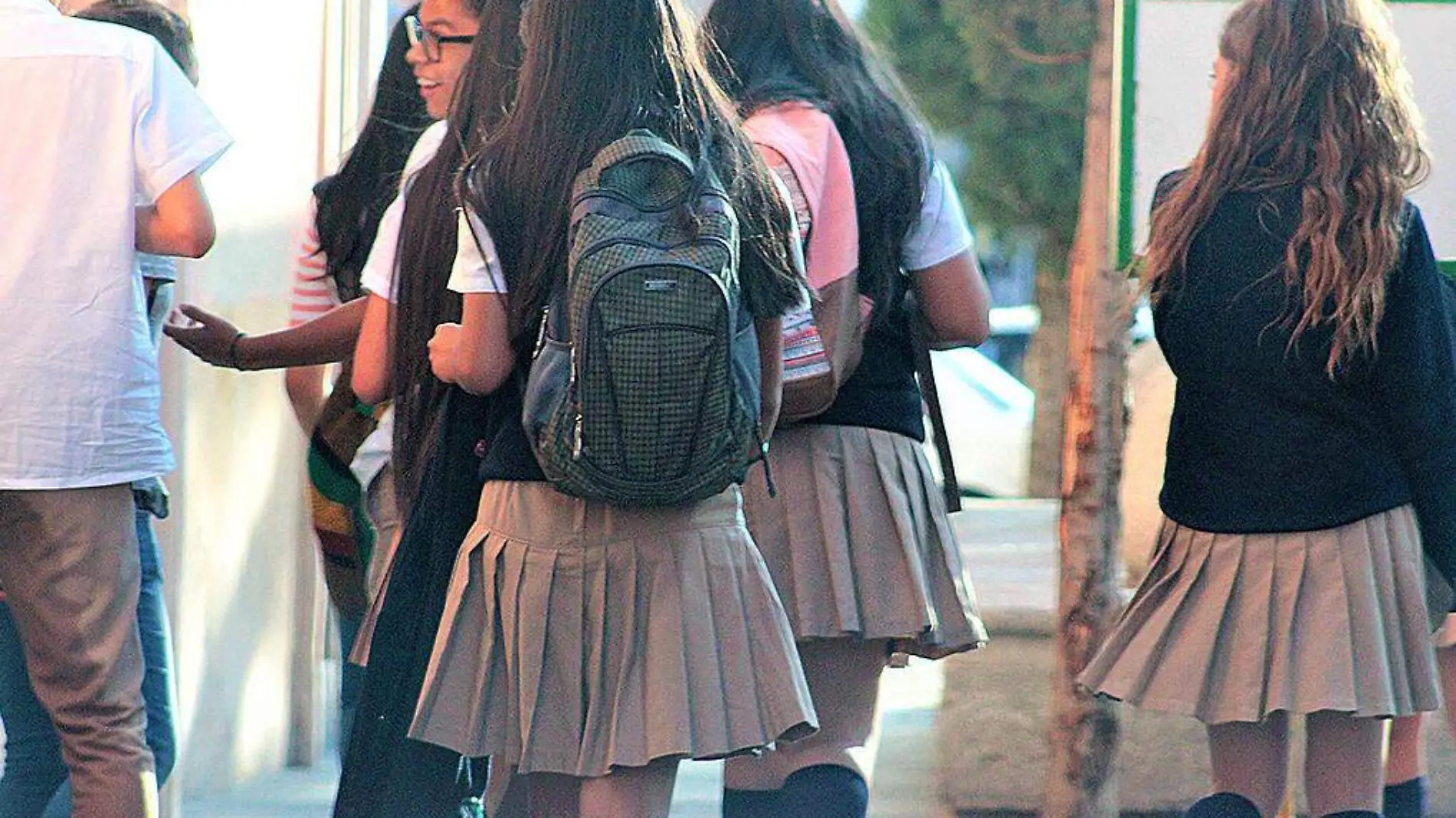 Estudiantes con mochilas caminando